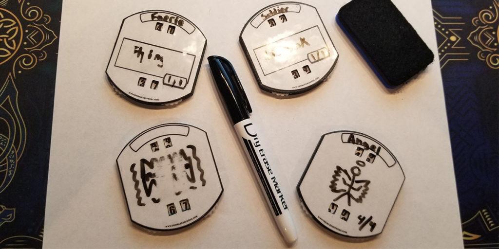 A collection of 4 Mass MTG Dry Erase Tokens with dual counters on them