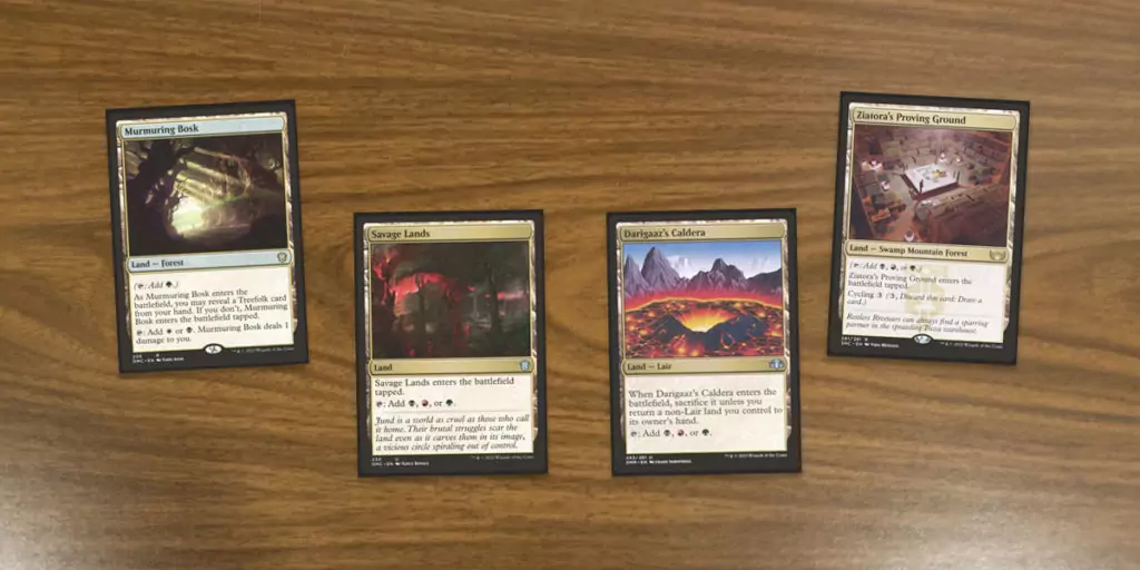 A small collection of MTG tri lands. These are 4 of the tri lands MTG printed in the colors of Jund. Cards shown are Murmuring Bosk,, Savage Lands, Darigaaz's Caldera and Ziatora's Proving Ground