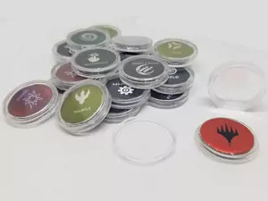 One best MTG accessories are Ikoria punch-out ability counters inside of penny coin capsules. Shown here are a bunch of punch-outs inside of these capsules.