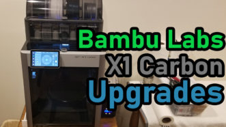 Featured image for the Bambu X1C Upgrades article. The photo shows a Bambu Lab X1 Carbon to the left with the words 'Bambu Labs X1 Carbon Upgrades' to the right in green, grey and blue text.