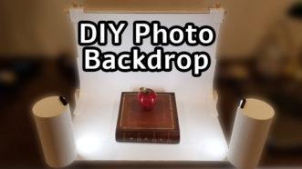 Image showing a DIY photo booth backdrop being used to capture an apple sitting on top of a book with the text 'DIY photo backdrop' over the image.
