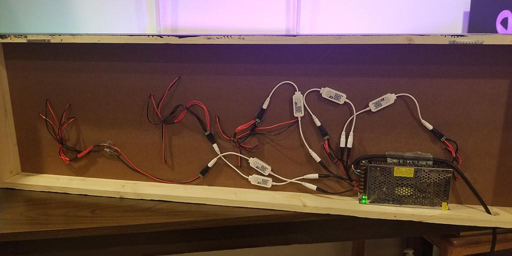 An image showing the backside of my completed 3D printed neon sign made up of 5 individual 3D printed light pieces. This is showing all the wiring and the connectors.