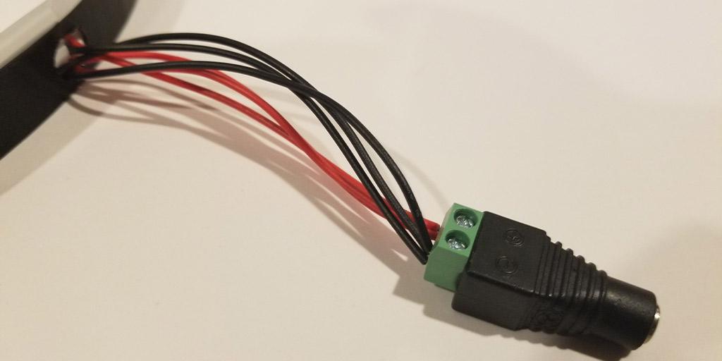 This image shows all the wires exiting the termination hole on the 3D printed neon sign shell and connected to a female DC barrel jack connector.